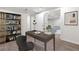 Basement home office featuring a desk and shelving unit, with a view into the living room at 5471 S Sherman St, Littleton, CO 80121