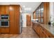 Gourmet kitchen featuring warm wood cabinetry, stainless steel appliances, and granite countertops at 5471 S Sherman St, Littleton, CO 80121