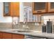 Close-up on modern kitchen sink with stainless steel faucet, with stylish tile backsplash and wood cabinetry at 5471 S Sherman St, Littleton, CO 80121