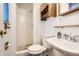 Cozy bathroom with tiled shower, toilet, vanity, and wooden cabinet at 3693 E Costilla Ave, Centennial, CO 80122