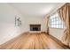 Bright living room featuring a brick fireplace, hardwood floors, and large window at 3693 E Costilla Ave, Centennial, CO 80122