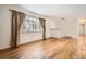 A living room with gleaming hardwood floors and a large window with curtains for natural light at 3693 E Costilla Ave, Centennial, CO 80122