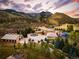 Expansive estate with lush landscaping, fountain, pool, and tennis court set against a stunning mountain backdrop at 6729 Bear Point Trl, Golden, CO 80403
