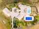 Stunning aerial view of estate with pool, tennis court, circular driveway and lush landscaping at 6729 Bear Point Trl, Golden, CO 80403