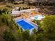 Luxury estate featuring a tennis court, pool and lush landscaping; all nestled against a scenic mountain range at 6729 Bear Point Trl, Golden, CO 80403