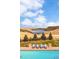 Gorgeous backyard pool area with inviting lounge chairs and a serene lake view at 6729 Bear Point Trl, Golden, CO 80403