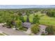 Aerial view of home with lush, green landscaping and a golf course in the distance at 8397 Chase Dr, Arvada, CO 80003
