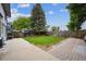 Lawn with a paver border, mature trees and wood fence at 8397 Chase Dr, Arvada, CO 80003