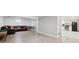 Spacious basement area with light flooring, a brown leather sofa, and an adjacent kitchen at 8397 Chase Dr, Arvada, CO 80003