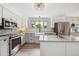 Bright kitchen with stainless appliances, island and white cabinets at 8397 Chase Dr, Arvada, CO 80003