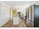 Bright kitchen with stainless steel appliances, granite counters and light wood floors at 8397 Chase Dr, Arvada, CO 80003