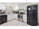 Kitchen featuring white cabinets, stainless steel appliances, and tile flooring at 8397 Chase Dr, Arvada, CO 80003