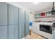 Convenient laundry room features storage cabinets, shelving, washer and dryer at 8397 Chase Dr, Arvada, CO 80003
