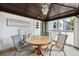 Enclosed sunroom with a gathering sign, round table, and outdoor view at 8397 Chase Dr, Arvada, CO 80003