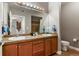 Well-lit bathroom with double sinks, wood cabinets, and a large mirror over a tile floor at 9019 E Panorama Cir # D416, Englewood, CO 80112