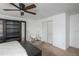 Bright bedroom with a ceiling fan and large dark colored wardrobe and a plush white chair with a bench at 3629 W Custer Pl, Denver, CO 80219