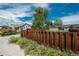 A street view showing a single-story home with a fenced front yard under a partly cloudy sky at 3629 W Custer Pl, Denver, CO 80219