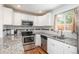Modern kitchen featuring granite countertops, stainless steel appliances, and white cabinets at 3629 W Custer Pl, Denver, CO 80219