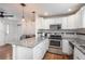 Modern kitchen featuring granite countertops, stainless steel appliances, and white cabinets at 3629 W Custer Pl, Denver, CO 80219