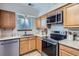 Updated kitchen featuring stainless steel appliances, light wood cabinets and fixtures at 5511 S Lowell Blvd, Littleton, CO 80123