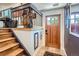 Inviting entryway with wood door, tile floor and staircase with custom iron railing at 1676 S Fairplay St, Aurora, CO 80012