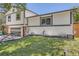 Well-maintained two-story home featuring a driveway, manicured lawn, and charming landscape at 1676 S Fairplay St, Aurora, CO 80012