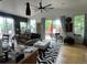 Bright living room featuring a ceiling fan, hardwood floors, and access to an outdoor deck at 1676 S Fairplay St, Aurora, CO 80012
