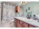 Practical bathroom showcasing a vanity, toilet, and shower with a floral curtain, designed for everyday use at 433 N 15Th Ave, Brighton, CO 80601