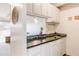 Cozy kitchen with breakfast bar featuring stainless steel sink and granite countertop at 1441 N Humboldt St # 302, Denver, CO 80218