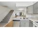 Open floor plan with kitchen flowing into living room with brick fireplace and staircase access at 1699 S Trenton St # 147, Denver, CO 80231