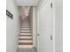 Interior staircase with white risers and wood treads adjacent to a white door at 1699 S Trenton St # 147, Denver, CO 80231