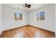 Bedroom featuring laminate wood flooring, a ceiling fan, and two windows providing lots of natural light at 1334 Carriage Dr, Longmont, CO 80501