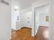 Hallway with laminate wood flooring leading to a laundry closet and bedroom with natural light, and a view of a window at 1334 Carriage Dr, Longmont, CO 80501