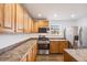 The eat-in kitchen features stainless steel appliances and abundant light wood cabinetry at 1334 Carriage Dr, Longmont, CO 80501