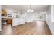 Spacious living room featuring wood floors, modern lighting, and an open concept design to the kitchen at 1334 Carriage Dr, Longmont, CO 80501