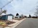 Exterior street view of a cozy home showcasing its neighborhood setting and detached garage at 4901 Bryant St, Denver, CO 80221