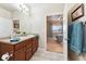 Bright bathroom with double vanity, tile flooring, and a glimpse of a bedroom at 12564 Madison Way, Thornton, CO 80241