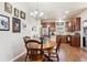 Dining room with wooden table and chairs, alongside a stylish chandelier and adjacent modern kitchen with stainless appliances at 12564 Madison Way, Thornton, CO 80241