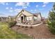 Charming single-story home featuring stone accents and a welcoming front porch with two chairs at 12564 Madison Way, Thornton, CO 80241