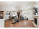 Bright living room with wood floors, a fireplace, and an open layout connecting to the kitchen and dining areas at 12564 Madison Way, Thornton, CO 80241