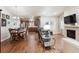 Inviting open-concept living space with wood floors and a cozy fireplace, seamlessly flowing into the kitchen and dining area at 12564 Madison Way, Thornton, CO 80241