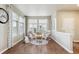 Cozy seating area with rocking chairs and a small table, bathed in natural light from large windows at 12564 Madison Way, Thornton, CO 80241