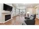 Open living room features wood floors, a fireplace, and a seating area near the bright windows at 12564 Madison Way, Thornton, CO 80241