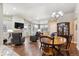 Open-concept living area featuring a fireplace, comfortable seating, hardwood floors, and a dining area with a stylish chandelier at 12564 Madison Way, Thornton, CO 80241