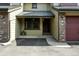 Charming townhouse front entrance with covered porch, brick accents, and well-maintained landscaping at 10842 W Evans Ave # 34, Lakewood, CO 80227