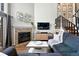 Inviting living room with a cozy fireplace, modern decor, and staircase to the upper level at 10842 W Evans Ave # 34, Lakewood, CO 80227