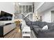 Spacious living room with stylish decor, a modern entertainment center, and staircase to the upper level at 10842 W Evans Ave # 34, Lakewood, CO 80227