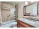 Well-lit bathroom featuring tile shower, granite countertop vanity, and modern fixtures at 9655 E Center Ave # 11D, Denver, CO 80247
