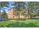 Exterior view of the building highlighting lush landscaping and mature trees at 9655 E Center Ave # 11D, Denver, CO 80247