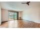 Bright living room with hardwood floors, a ceiling fan, and sliding glass doors to the patio at 9655 E Center Ave # 11D, Denver, CO 80247